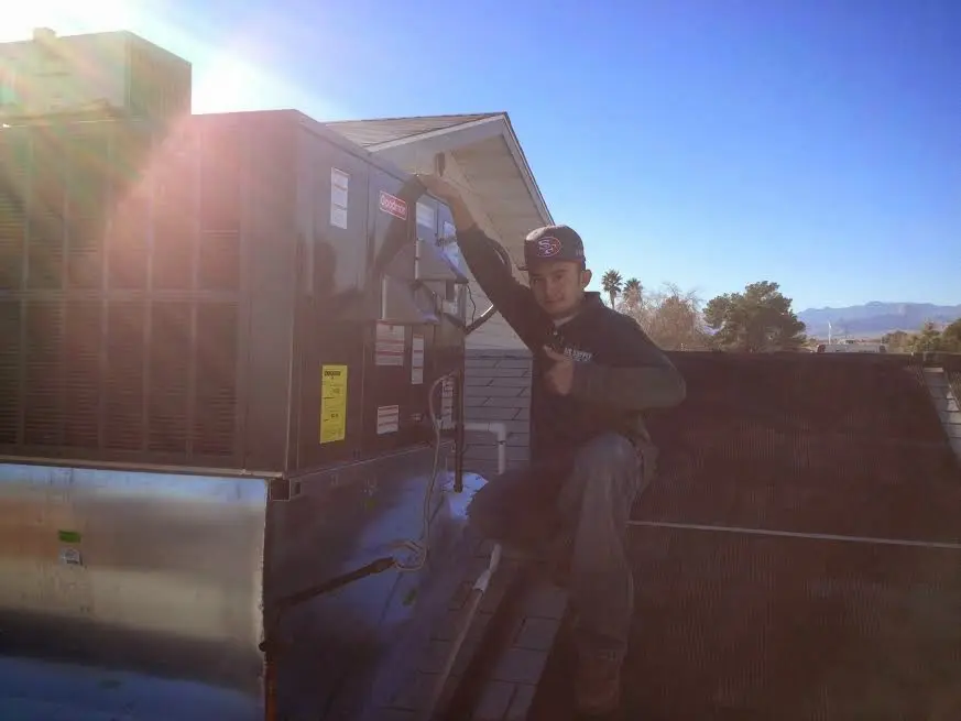 HVAC technician performing Boiler Repair on a rooftop unit in Knightdale